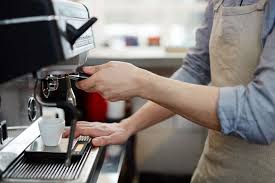 Trainee learning espresso preparation with job coach
